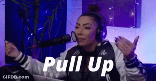 A Woman Wearing Headphones Is Sitting In Front Of A Microphone In A Room . GIF