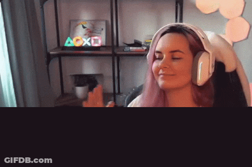 A Woman Wearing Headphones Is Sitting In Front Of A Microphone In Front Of A Sign That Says Aoxo GIF