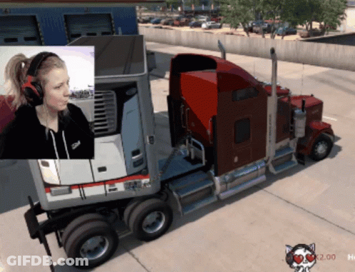 A Woman Wearing Headphones Is Sitting In Front Of A Semi Truck GIF