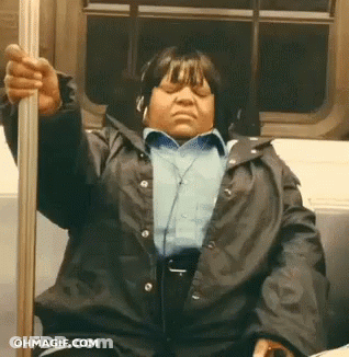 A Woman Wearing Headphones Is Sitting On A Train With Her Eyes Closed .. GIF