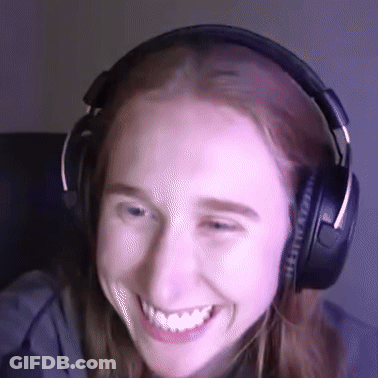 A Woman Wearing Headphones Is Smiling And Looking At The Camera GIF