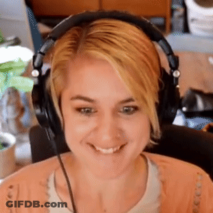 A Woman Wearing Headphones Is Smiling And Making A Funny Face GIF