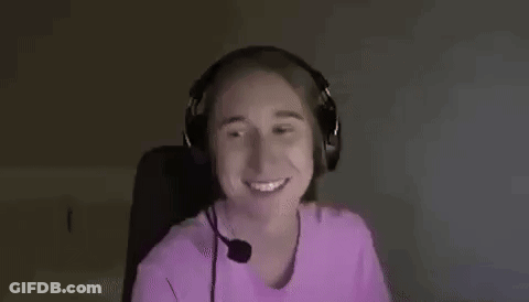 A Woman Wearing Headphones Is Smiling And Making A Funny Face . GIF