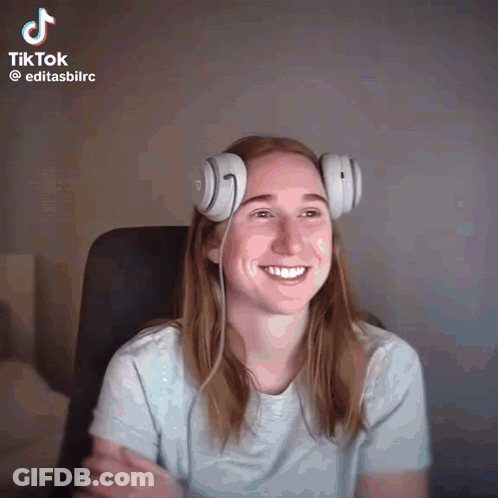 A Woman Wearing Headphones Is Smiling In A Tiktok GIF