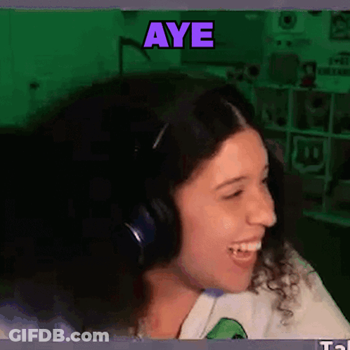 A Woman Wearing Headphones Is Smiling With The Word Aye Written Above Her GIF