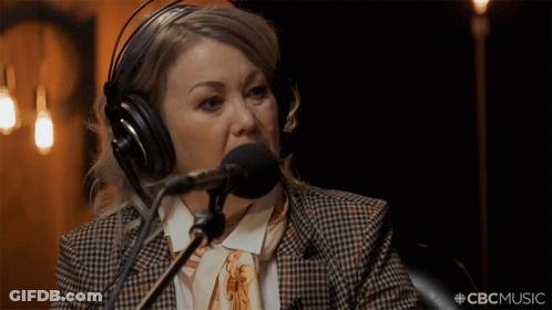 A Woman Wearing Headphones Is Speaking Into A Microphone With The Hashtag #Cbcmusic GIF