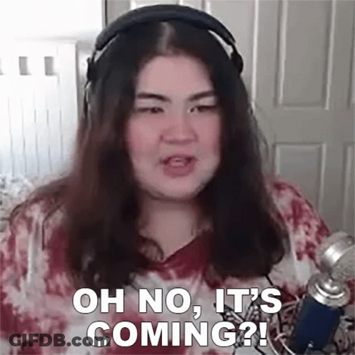 A Woman Wearing Headphones Is Talking Into A Microphone And Says `` Oh No , It 'S Coming '' . GIF