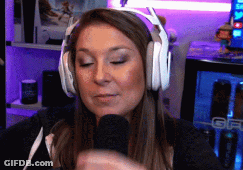 A Woman Wearing Headphones Is Talking Into A Microphone In Front Of A Geico Can GIF