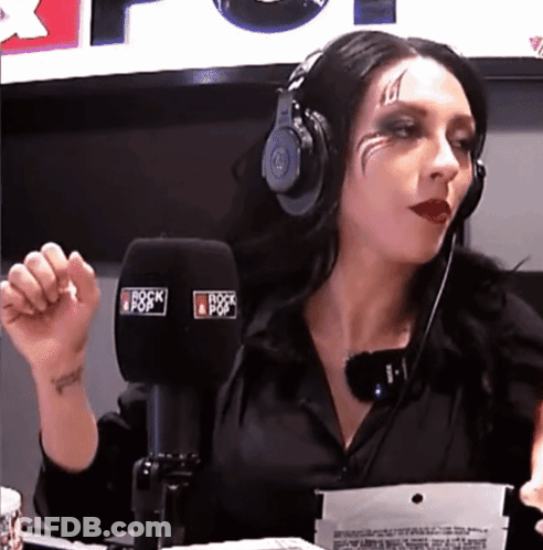A Woman Wearing Headphones Is Talking Into A Microphone That Says Rock Pop GIF