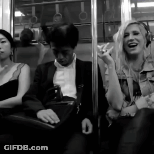 A Woman Wearing Headphones Laughs While Sitting Next To A Man GIF