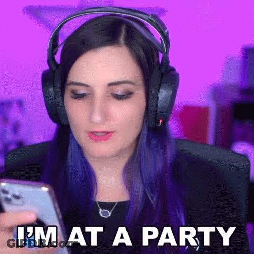 A Woman Wearing Headphones Looks At Her Phone With The Words I 'M At A Party Below Her GIF