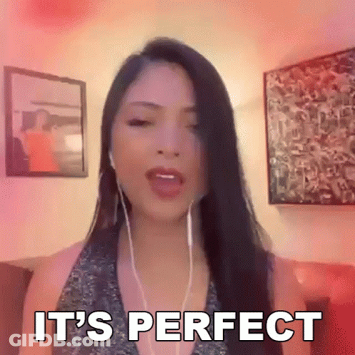 A Woman Wearing Headphones Says It 'S Perfect In Front Of A Pink Wall GIF
