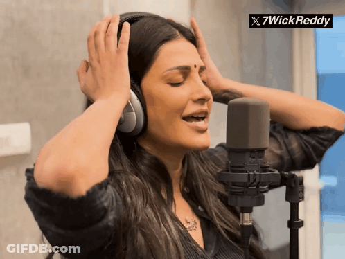A Woman Wearing Headphones Singing Into A Microphone With A 7Wickreddy Logo In The Corner GIF