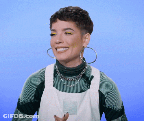 A Woman Wearing Hoop Earrings And An Apron With The Word Dickies On It Smiles GIF