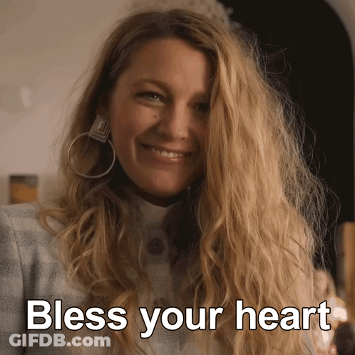 A Woman Wearing Hoop Earrings Smiles With The Words Bless Your Heart Above Her GIF