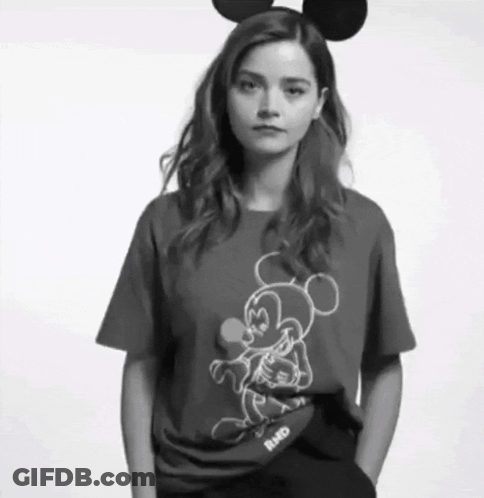 A Woman Wearing Mickey Mouse Ears And A Mickey Mouse Shirt GIF