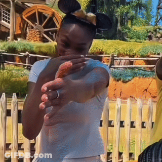 A Woman Wearing Mickey Mouse Ears Covering Her Face GIF