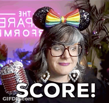 A Woman Wearing Mouse Ears And Glasses Is Holding A Microphone And Saying Score ! GIF