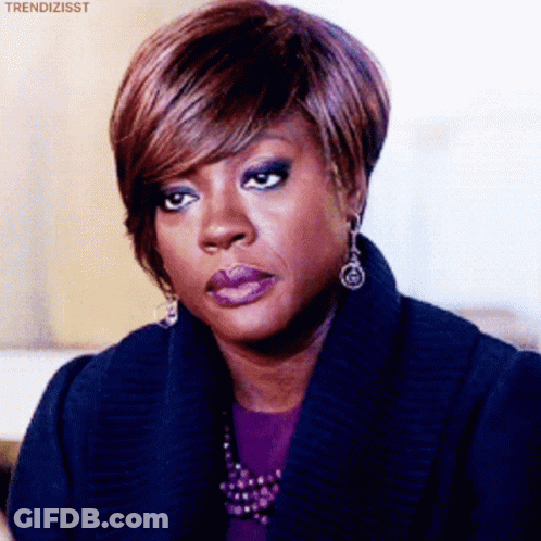 A Woman Wearing Purple Lipstick And Earrings Is Making A Face . GIF