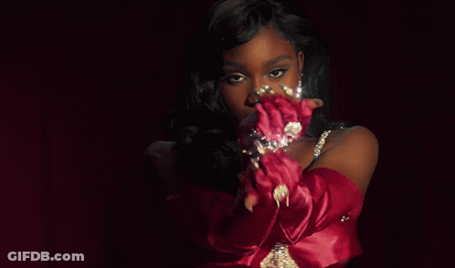 A Woman Wearing Red Gloves And A Necklace With Diamonds GIF