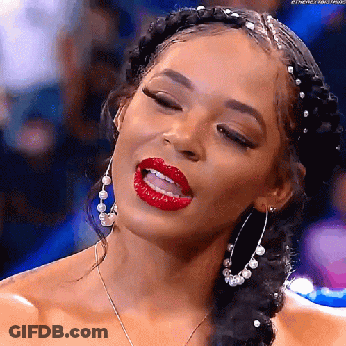 A Woman Wearing Red Lipstick And Hoop Earrings Is Making A Funny Face . GIF