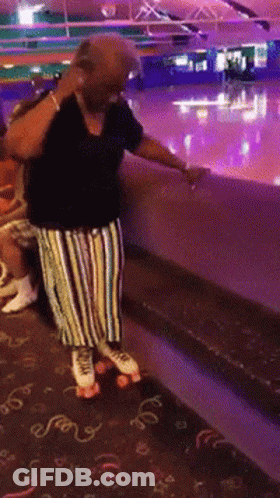 A Woman Wearing Roller Skates Is Standing On A Carpet That Says ' Swirls ' On It GIF