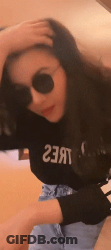 A Woman Wearing Sunglasses And A Black Shirt That Says ' 23 ' On It GIF