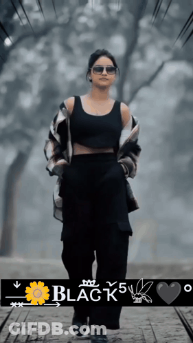 A Woman Wearing Sunglasses And A Black Tank Top Is Walking Down A Path With The Words Black 5 Written Below Her GIF