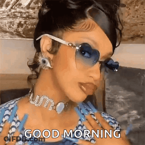 A Woman Wearing Sunglasses And A Choker Is Giving A Good Morning Message . GIF