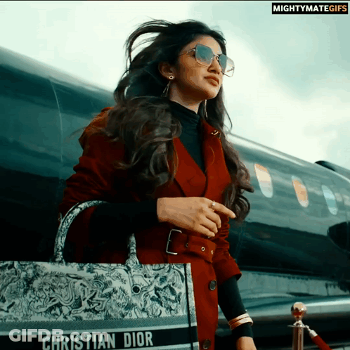 A Woman Wearing Sunglasses And A Christian Dior Purse GIF
