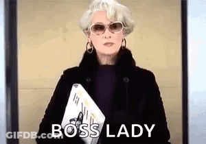 A Woman Wearing Sunglasses And A Fur Coat Is Holding A Magazine And Says Boss Lady . GIF