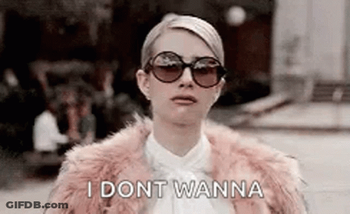 A Woman Wearing Sunglasses And A Fur Coat Is Standing On A Street . GIF