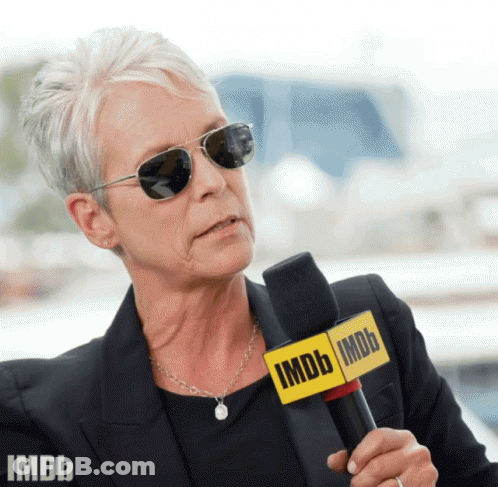 A Woman Wearing Sunglasses And A Microphone That Says Imdb On It GIF