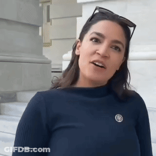 A Woman Wearing Sunglasses And A Pin With The Letter S On It . GIF