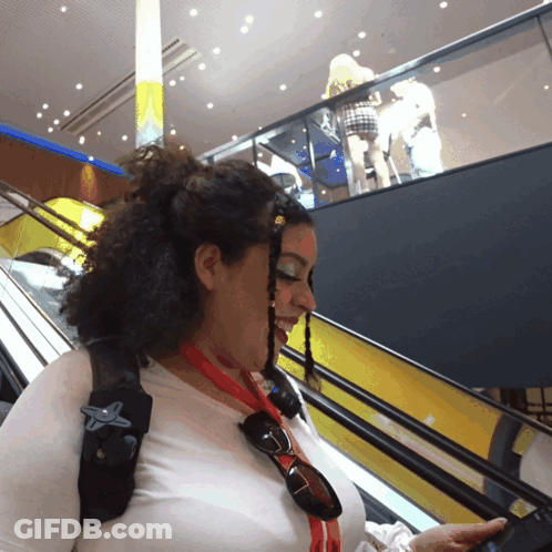 A Woman Wearing Sunglasses And A Red Lanyard With A Star On It GIF