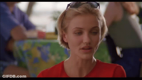 A Woman Wearing Sunglasses And A Red Shirt Is Looking At The Camera GIF