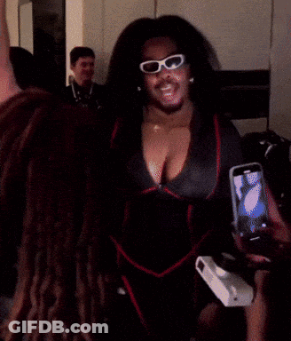 A Woman Wearing Sunglasses And A Robe Is Taking A Selfie GIF