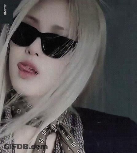A Woman Wearing Sunglasses And A Scarf Has The Word Mora On The Bottom Right GIF