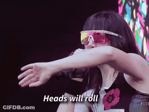 A Woman Wearing Sunglasses And A Shirt That Says Heads Will Roll GIF