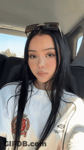 A Woman Wearing Sunglasses And A White Shirt That Says ' Ogood ' On It GIF