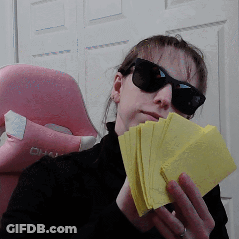 A Woman Wearing Sunglasses And Holding A Stack Of Yellow Cards GIF