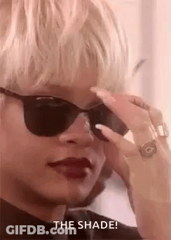 A Woman Wearing Sunglasses And Red Lipstick Is Looking Down At Something . GIF