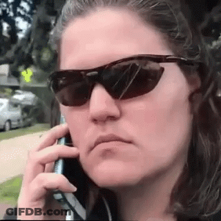 A Woman Wearing Sunglasses And Talking On A Cell Phone GIF