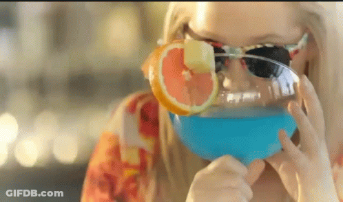 A Woman Wearing Sunglasses Drinking A Blue Drink GIF