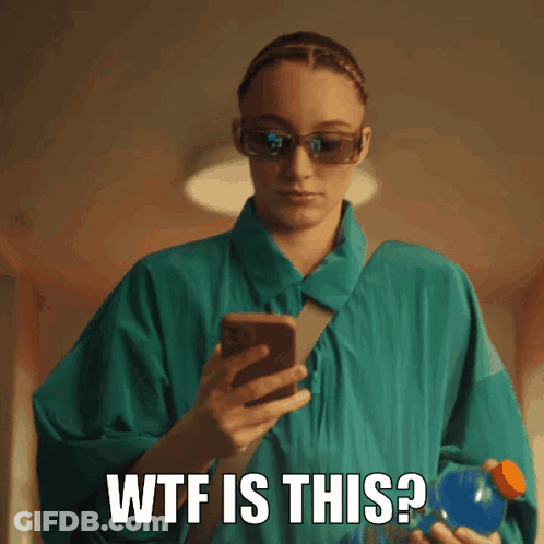 A Woman Wearing Sunglasses Is Holding A Bottle And Looking At Her Phone With The Words Wtf Is This Written Below Her GIF