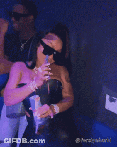 A Woman Wearing Sunglasses Is Holding A Can Of Soda And Taking A Picture Of Herself GIF