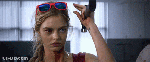A Woman Wearing Sunglasses Is Holding A Knife GIF