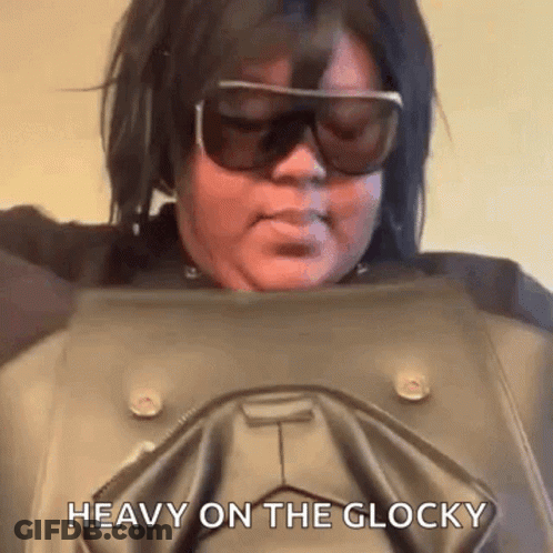 A Woman Wearing Sunglasses Is Holding A Leather Jacket And Says `` Heavy On The Glocky '' . GIF