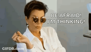 A Woman Wearing Sunglasses Is Sitting In A Chair And Saying `` Be Afraid ! I 'M Thinking '' . GIF