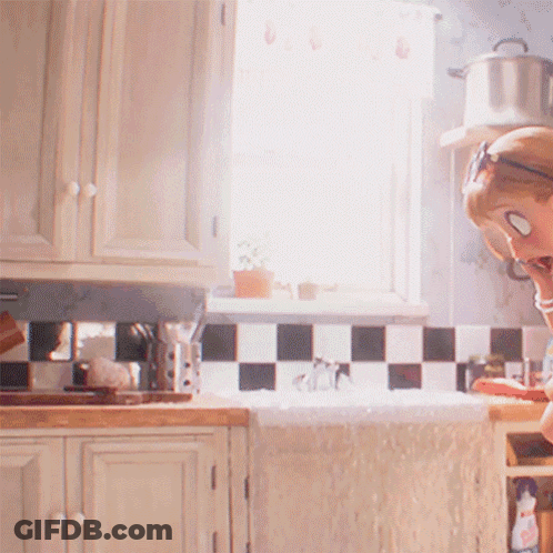 A Woman Wearing Sunglasses Is Sitting In A Kitchen GIF
